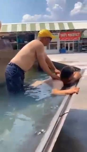 Sıcaktan bunalan işçiler, iş makinesinin kovasına doldurdukları suda serinledi - Resim: 1